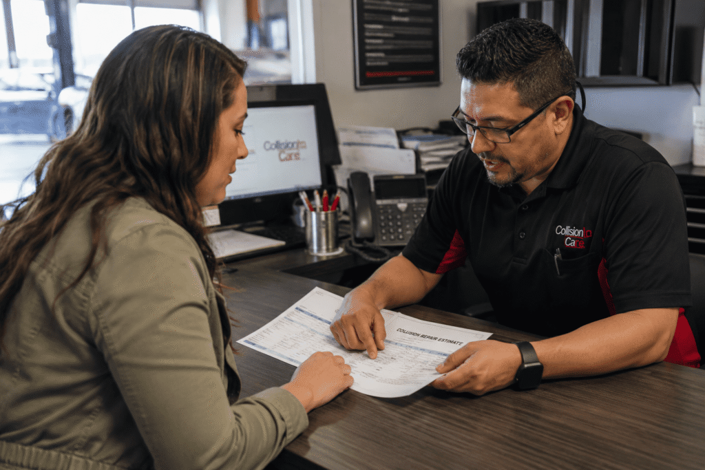 Car owner discussing collision repair estimates and hidden damage findings